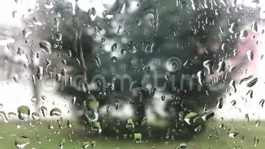 多云背景的窗户玻璃表面有雨滴。 雨滴的自然模式。 在雨中开车。 从这里看视频