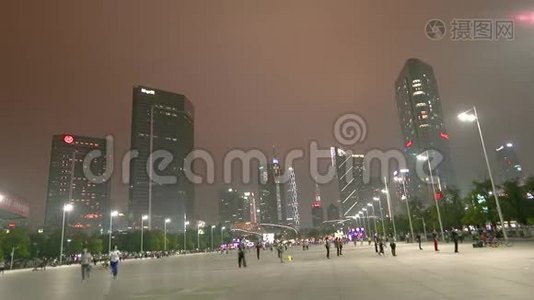 广州夜间时间推移，摩天大楼在背景。 人们绕着这个地区的时间圈走。视频