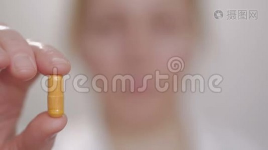女人拿出一块药片，用手指拿着它，然后吞下它，用水喝它视频