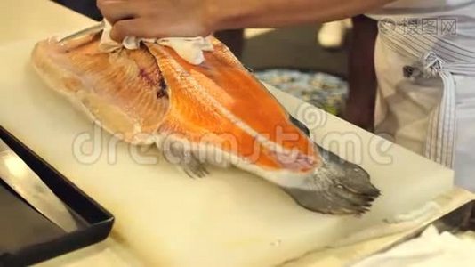 寿司厨师的特写展示了一个`的能力切片新鲜鲑鱼在寿司吧。视频