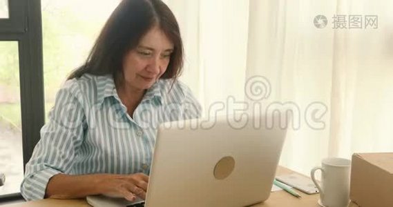 开朗的女商人带着笔记本电脑庆祝新的视频