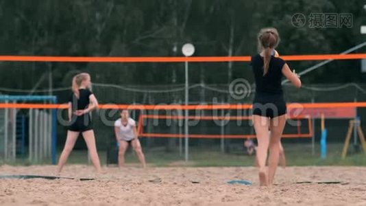 女排发球。 女人准备为排球服务，同时站在海滩上慢动作。视频