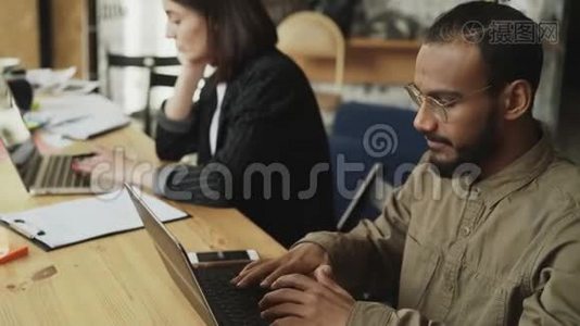 非裔美国人集中男子在loft办公室的笔记本电脑上打字，与女性一起从事软件开发视频
