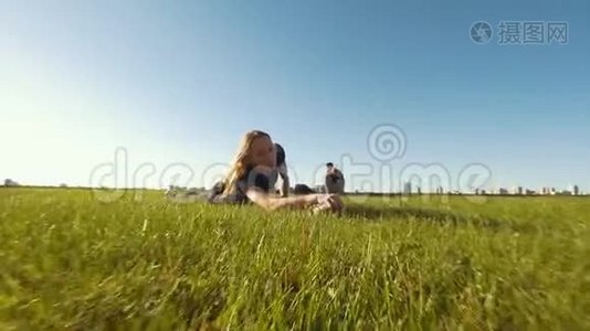 夏日里，年轻灵活的女人在草地上的树枝上伸展视频