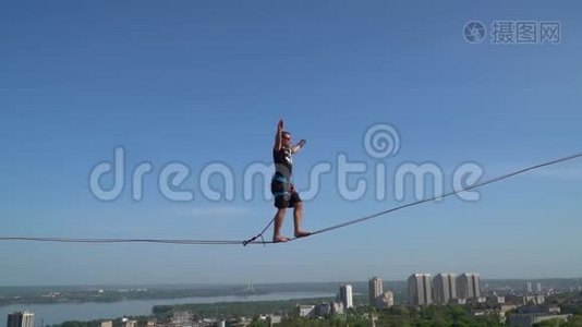 一个穿着运动服的男人，在城市背景下，在高空穿着绳子，动作缓慢视频