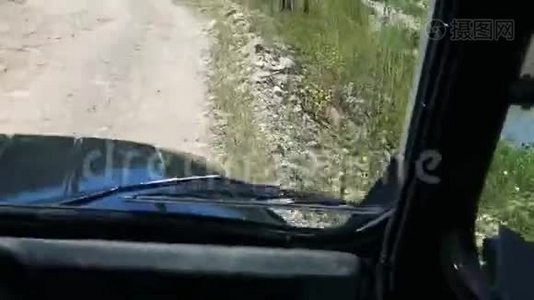 POV驾驶吉普车在绿色植物之间的崎岖道路上行驶视频