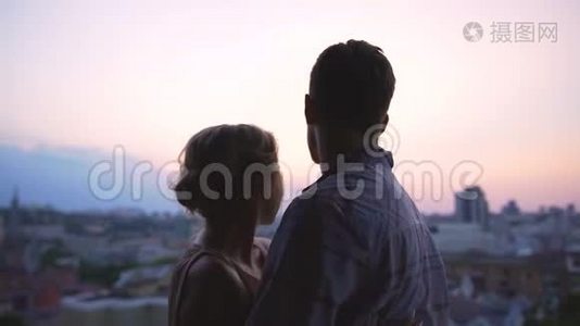 新婚夫妇站在高楼的屋顶上，欣赏着城市的全景视频