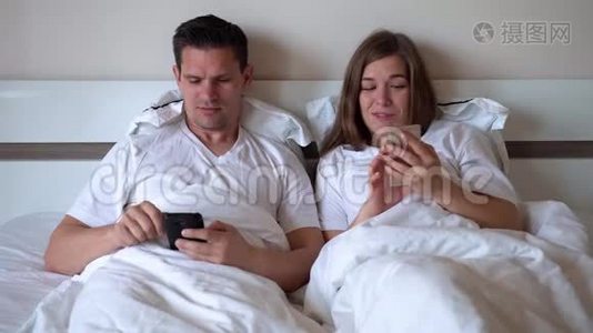 配偶躺在床上看智能手机视频