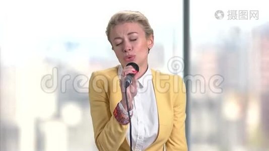 漂亮的女人正在用麦克风唱歌。视频