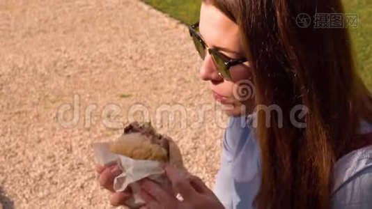 戴太阳镜的女人吃汉堡包视频