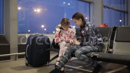 两个疲惫的女孩晚上在机场等你的航班视频