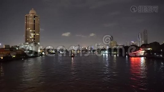 从河流和夜晚的船只交通看天际线上的摩天大楼视频