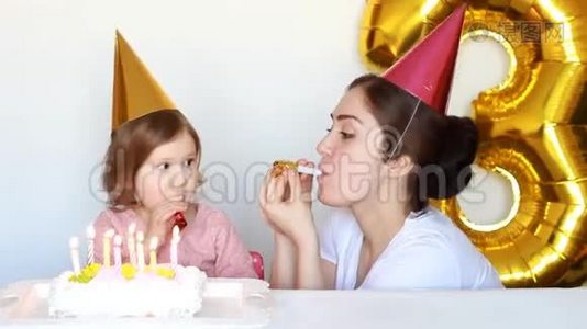 生日快乐的妈妈和孩子，生日蛋糕。母亲她的女儿在白色的背景下微笑和大笑。3年视频