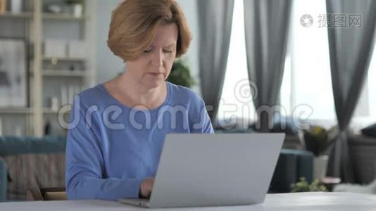 兴奋的老年妇女庆祝成功，在笔记本电脑上工作视频