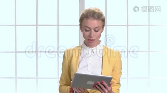 穿黄色夹克和平板电脑的女商人。视频