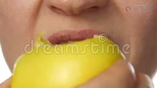 健康的女人在白色背景下吃苹果。 特写嘴唇。 健康的食物和节食的概念。 4K视频