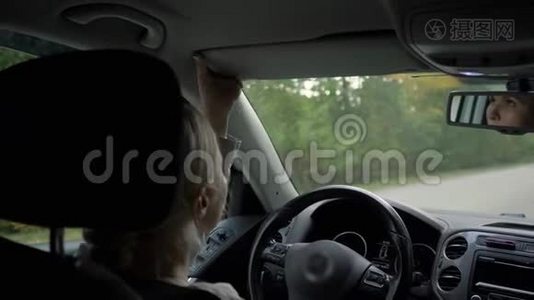年轻的金发女人在车里画她的嘴唇。视频