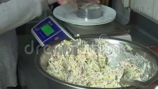 厨师把一份肉沙拉和蔬菜放在盘子里，放在餐馆厨房的秤上视频