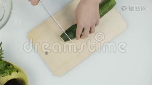 切黄瓜做生菜.. 在木制厨房板上切蔬菜。 顶视图4K视频