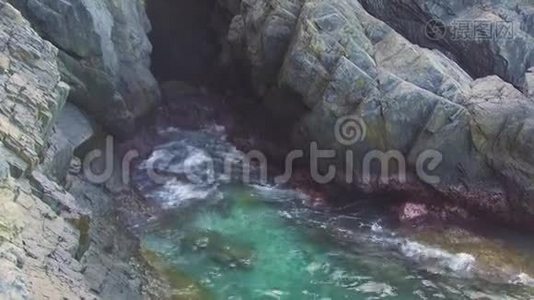 碧海的水波溅落在石崖上。 波浪在悬崖上破碎。 蓝色海水和大石头视频