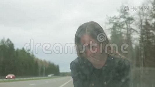 年轻的棕色头发的女人打开了一辆破车的引擎盖视频