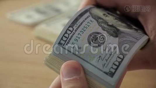 商人`的手在桌子上数着一百美元的钞票视频