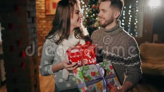 一对年轻夫妇正在拿圣诞礼物。视频