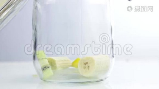 把水果片放进玻璃罐子里。 做水果鸡尾酒视频
