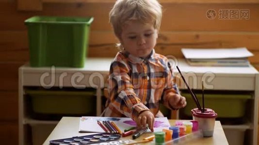 可爱的小男孩在他的相册里画画。 幼儿教育、绘画、天赋、幸福家庭和养育子女的概念视频