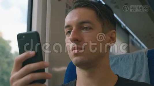 年轻人在火车上使用智能手机，录音和滚动视频
