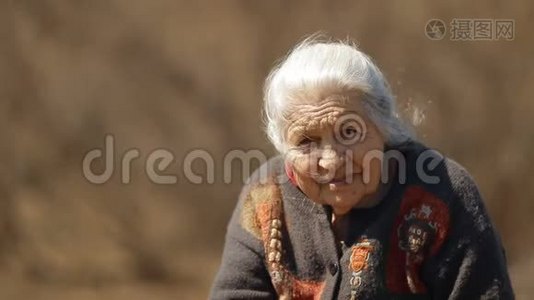 坐在公园里微笑的快乐老妇人的慢镜头肖像。视频