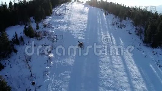 风景优美的冬季空中飞行无人机飞越山区和滑雪场。 雪猫开始它`转移，准备斜坡视频