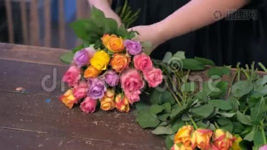 花商女人在商店里用五颜六色的小玫瑰做花束，双手特写。视频