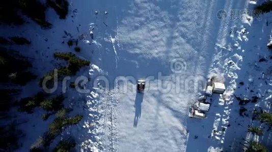 风景优美的冬季空中飞行无人机飞越山区和滑雪场。 雪猫开始它`转移，准备斜坡视频