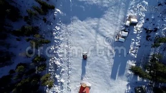 风景优美的冬季空中飞行无人机飞越山区和滑雪场。 雪猫开始它`转移，准备斜坡视频