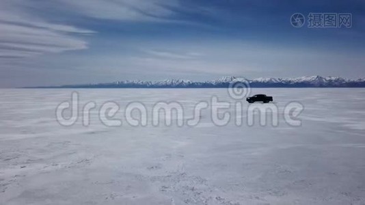 在冬季景观中驾驶汽车的无人机空中景观和高速驾驶过冰冻的湖泊。视频