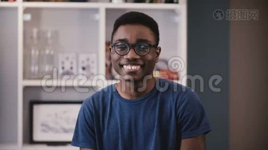 非裔美国大学生肖像。 戴眼镜的快乐黑人年轻人微笑，然后变得严肃。 情绪4K视频