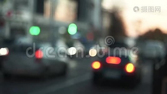 傍晚城市的街道从汽车的前灯发出光。视频