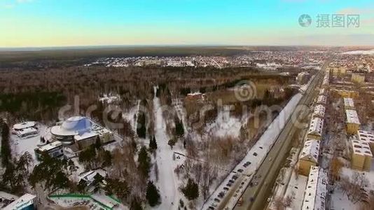 直升机飞过冬天的城市，靠近森林。 公园游憩区视频
