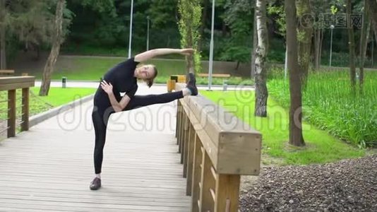 夏季在公园的木桥上进行伸展训练。 慢动作。视频