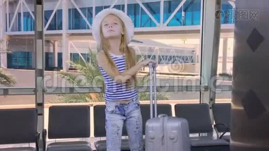 机场候机室里带旅行箱等候飞机的少女视频