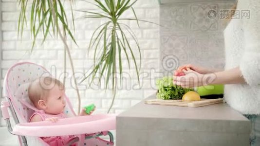 可爱的孩子看着妈妈做饭。 女性烹饪蔬菜视频