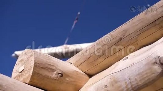 木质房屋的特写和带有木材的起重吊车.. 剪辑。 起重机背景下正在建造的木屋视频
