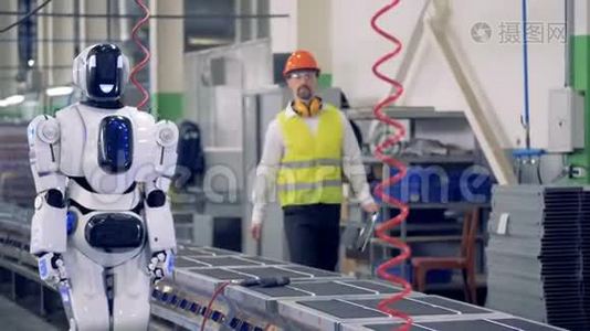 工程师控制机器人在工厂的传送带上工作。 4K.视频