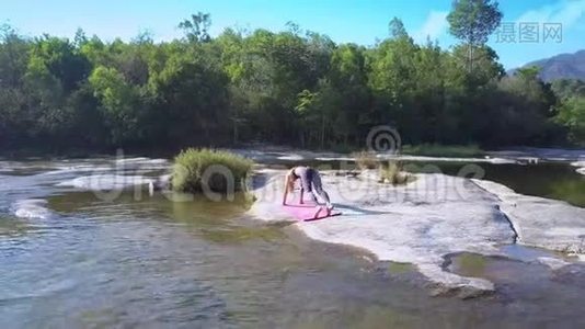 在河石的瑜伽姿势中腿上的女孩平衡视频