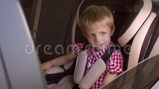 小快乐的男孩坐在一辆小汽车的座位上，竖起大拇指。视频