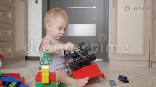 可爱的小男孩在家里地板上玩一个大汽车玩具。 小孩子在室内玩玩具车。 未来司机视频