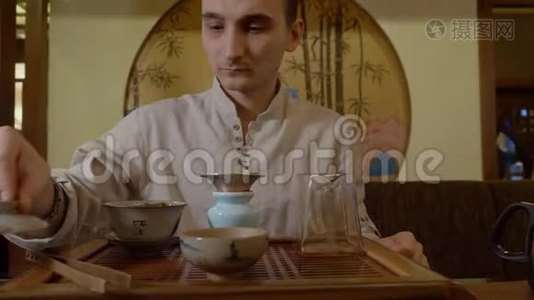 茶道大师用烧水壶浇热水，用中国式的茶道视频