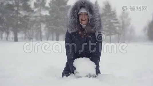 美丽的女人坐在雪堆里。 冬天公园里快乐的散步视频