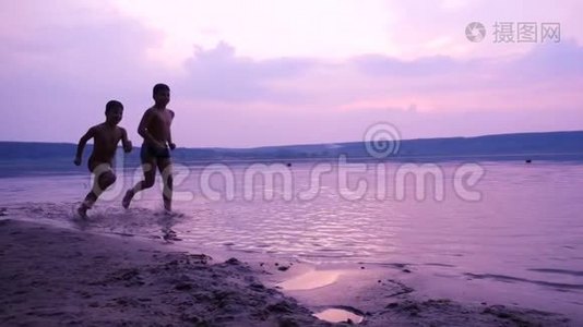 两个男孩沿着河岸奔跑的剪影视频